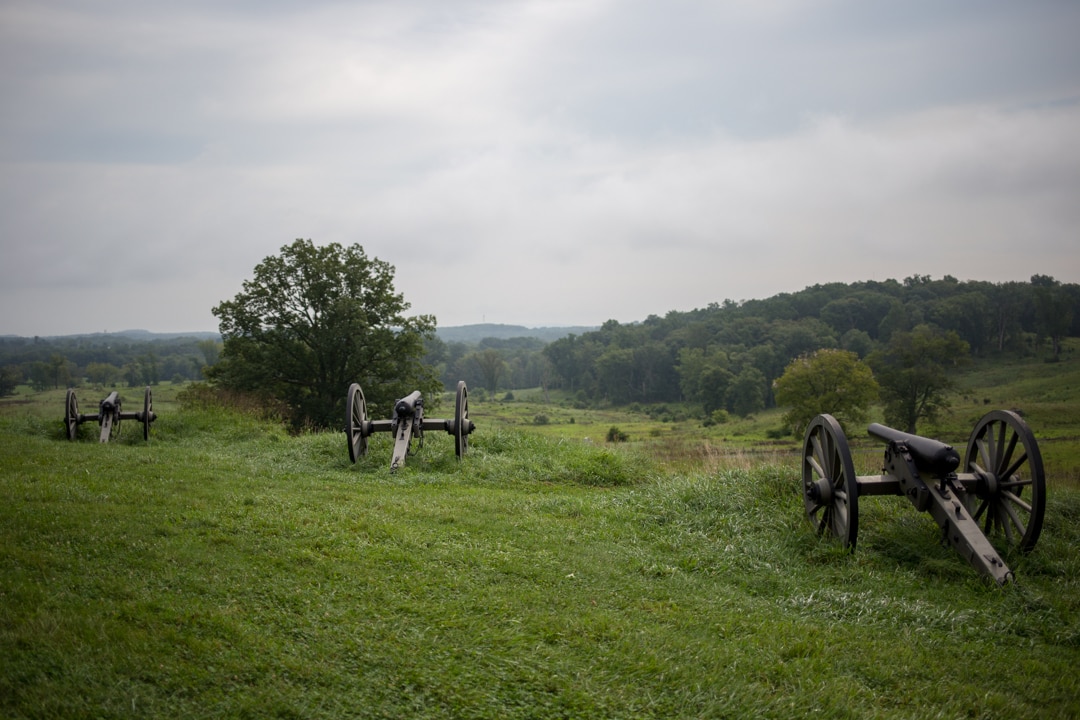 a battlefield with three civil war-era canon