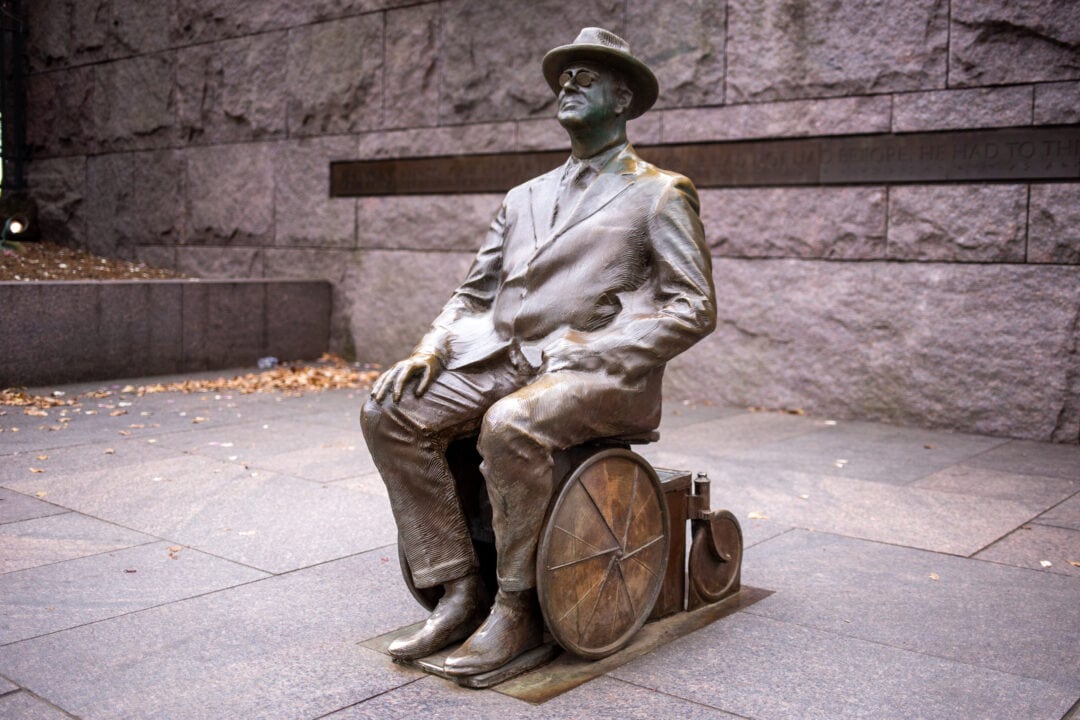 a bronze statue of franklin delano roosevelt sitting in a wheelchair 