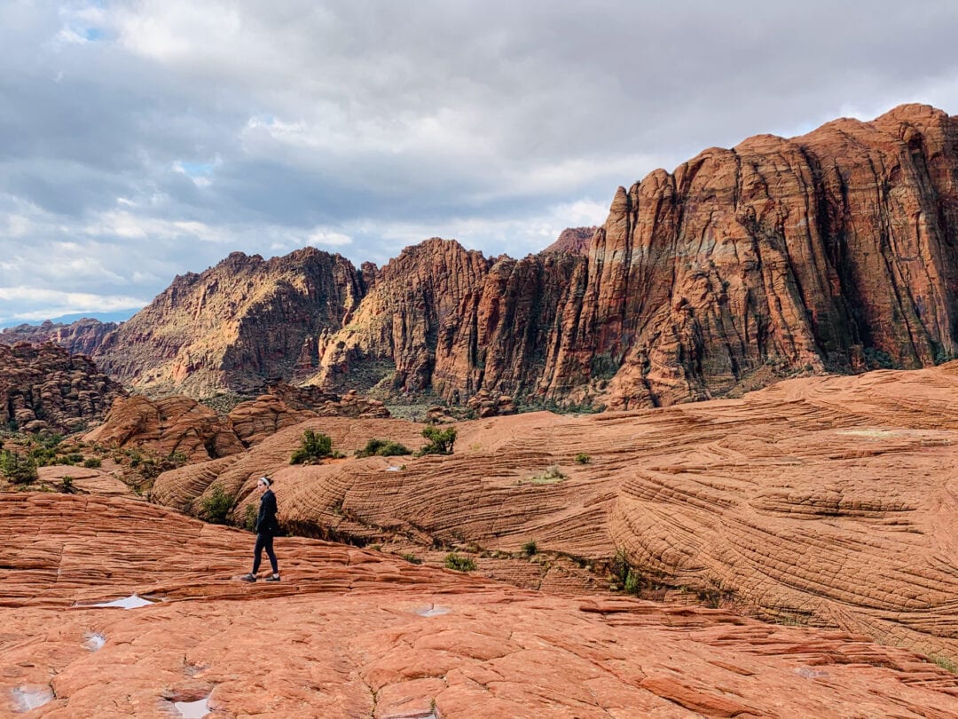 Woman walks among red rocks in state park