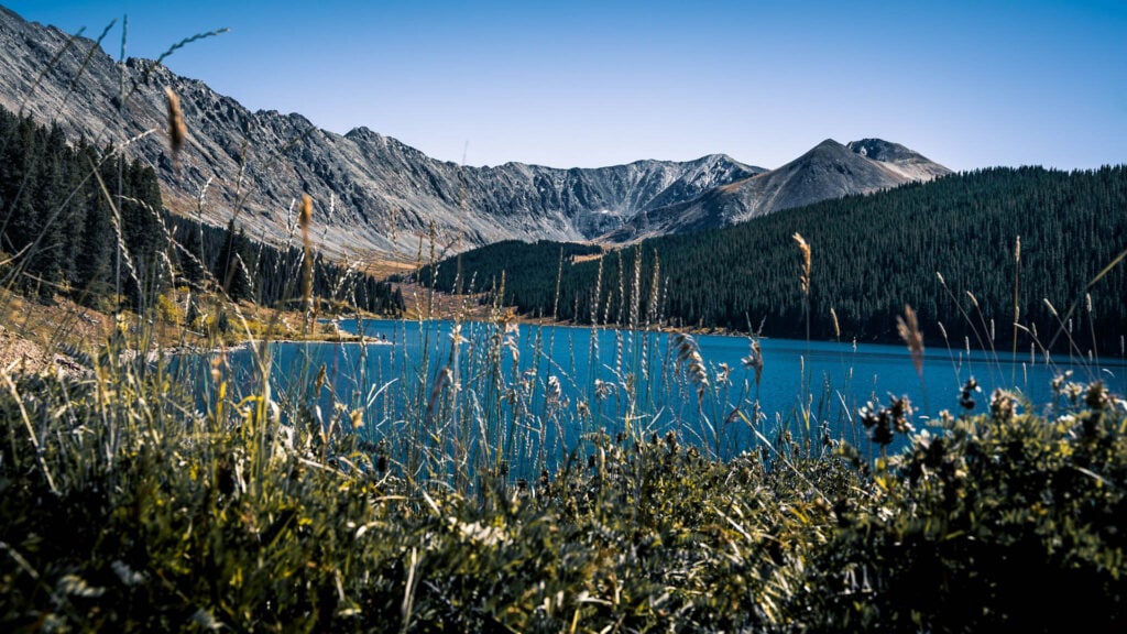 Rocky Mountain peaks stand on the other side of a blue lake
