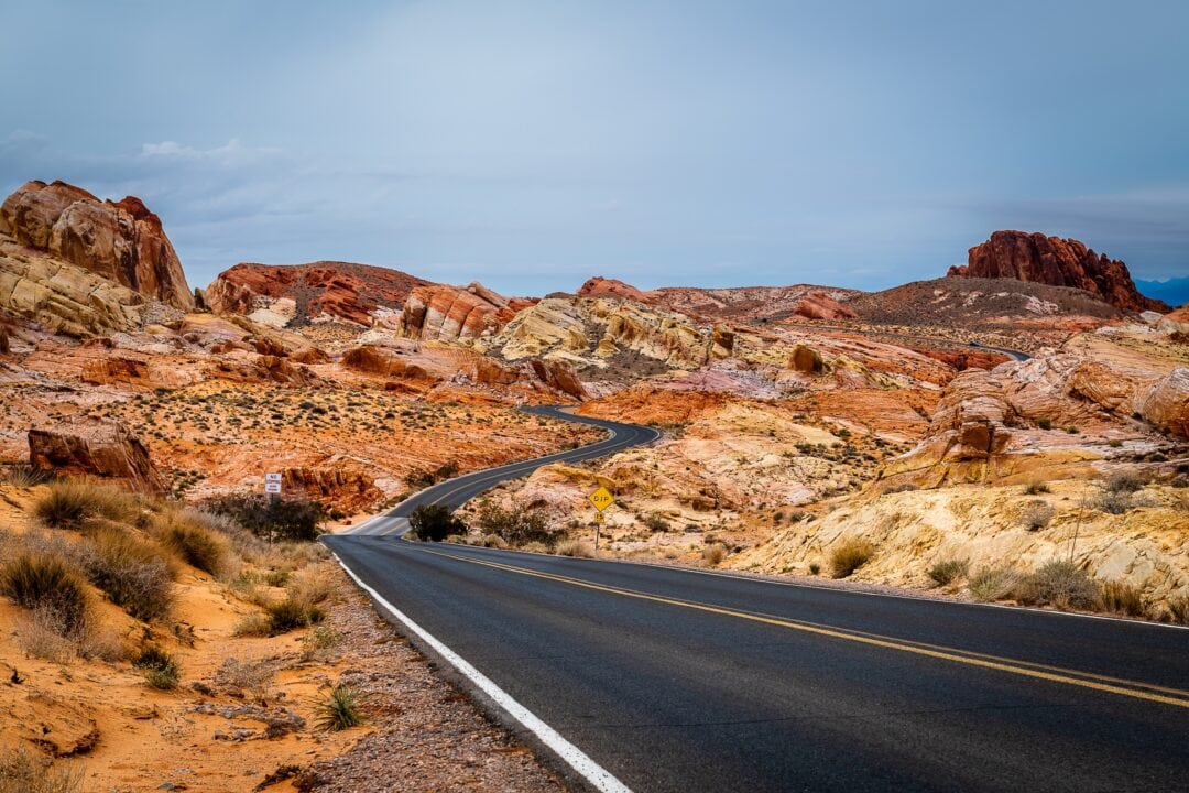 Roadway leading through a desert landscape of red rock formations