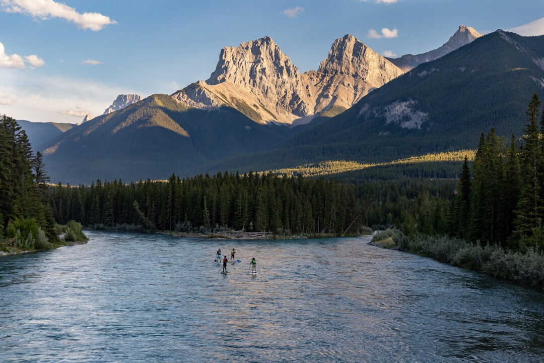 Paddler on river in Canada amongst rocky peaks