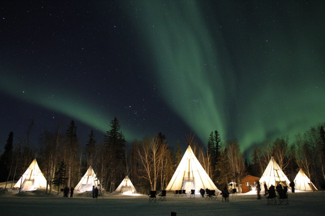 Northern Lights shining brightly behind a-frame homes