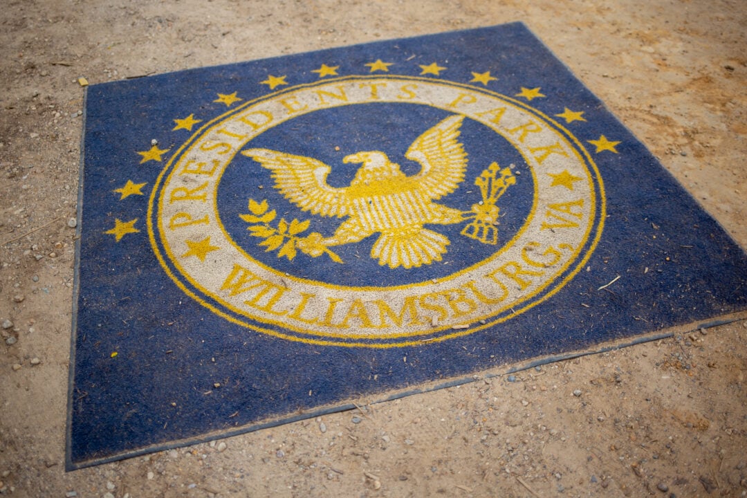 a blue and yellow carpet on the dirt ground with the presidential seal