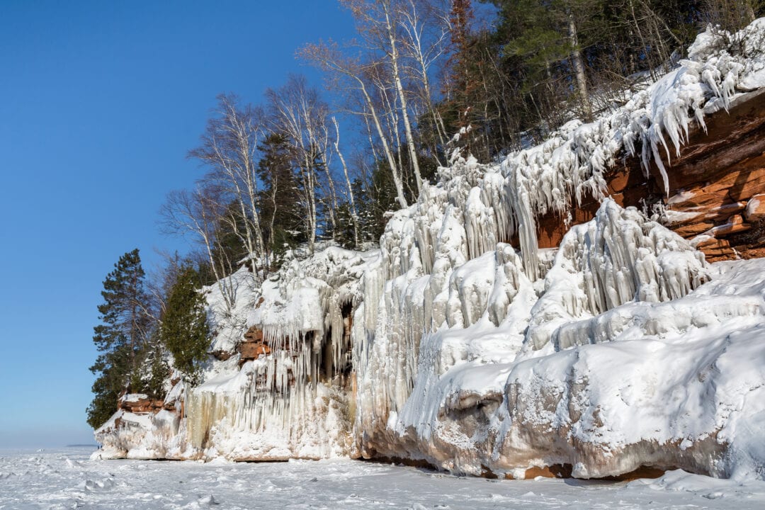 cliffs covered in ice and snow formations near the water