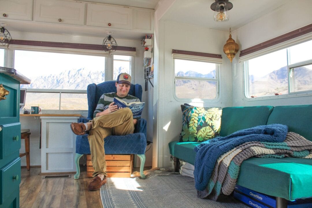 Person reading in chair in renovated RV