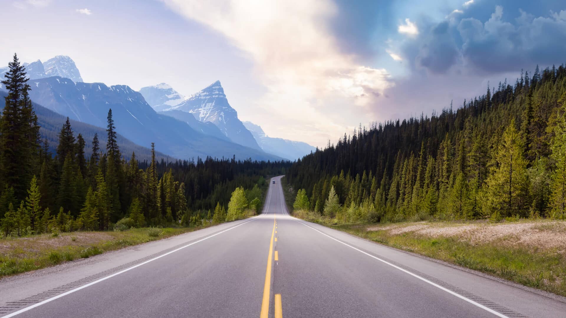 Driving down open road looking at mountain landscape in the distance.
